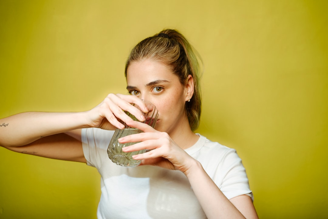 A woman drinking water — hydration is one of the simplest interventions for dry mouth