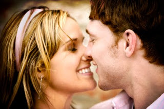 young couple smiling while about to kiss