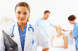Woman doctor looking at camera while nurses help patient in the background