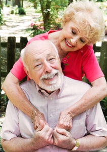 Older couple smiling and holding hands