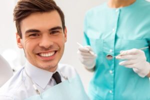 A man smiling during his appointment with his dental hygienist