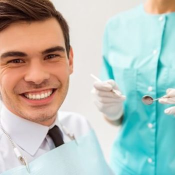 A man smiling during his appointment with his dental hygienist