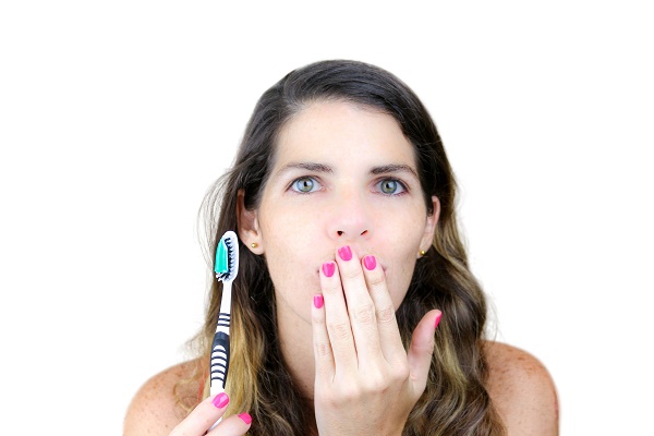 Closeup of an attractive young woman with a toothbrush